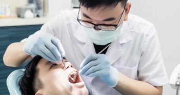 Asian dentist examining male asian patient teeth providing affordable and quality dental care